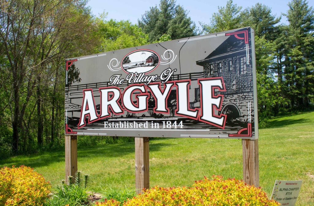 Outdoor sign that says 'Welcome to Argyle Established 1844' in the summer